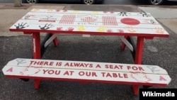 The message on this table in Wolfville, Nova Scotia, aligns with the town's attitude toward helping refugees. A community group from Wolfville has been among those in Canada to take primary responsibility for helping refugees become established in the country. (Wikimedia Commons)