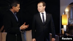 Russian Prime Minister Dmitry Medvedev (R) takes part in an interview with CNN news channel in Davos January 23, 2013.