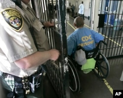 In this April 9, 2008 file photo, a wheelchair bound inmate wheels himself through a check point at the California Medical Facility, in Vacaville, Calif.