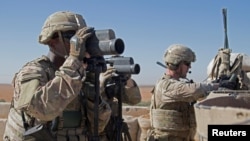 FILE - U.S. Soldiers scan the area during a combined joint patrol in Manbij, Syria, Nov. 1, 2018. 