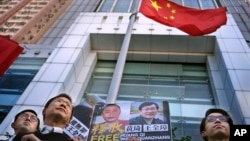 Người biểu tình cầm hình ảnh ủng hộ luật sư nhân quyền Vương Toàn Chương (Wang Quanzhang) bên ngoài văn phòng liên lạc Trung Quốc ở Hong Kong, hôm 29/1/2019. Mỹ kêu gọi Bắc Kinh cho phép người luật sư nổi tiếng của Trung Quốc được đi lại tự do sau khi ra tù.