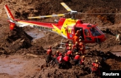 Members of a rescue team search for victims after a tailings dam owned by Brazilian mining company Vale SA collapsed, in Brumadinho, Brazil, Jan. 28, 2019.