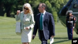 FILE - White House senior adviser Kellyanne Conway, left, and White House Chief of Staff Reince Priebus walk across the South Lawn of the White House in Washington, May 17, 2017. Conway and Priebus are among administration officials who have been granted ethics waivers.
