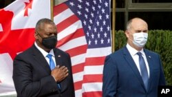 U.S. Defense Secretary Lloyd Austin, left, and Georgian Minister of Defense Juansher Burchuladze attend a welcome ceremony in Tbilisi, Georgia, Oct. 18, 2021. 