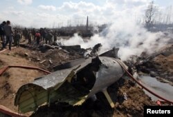 People stand next to the wreckage of Indian Air Force's helicopter after it crashed in Budgam district in Kashmir, Feb. 27, 2019.