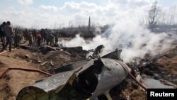 Warga menonton rongsokan sebuah jet tempur India jatuh di Budgam, Kashmir-India Rabu (27/2).