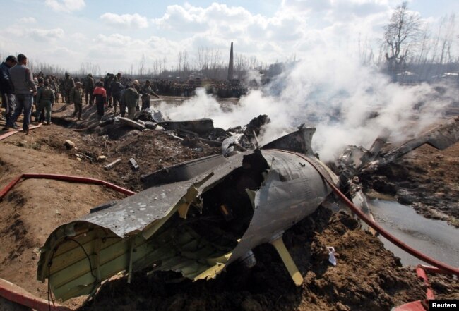People stand next to the wreckage of Indian Air Force's helicopter after it crashed in Budgam district in Kashmir, Feb. 27, 2019.
