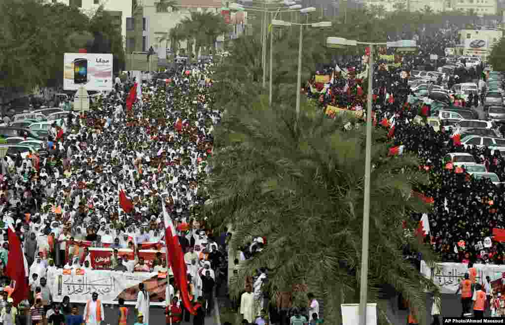 Miles de manifestantes anti gobierno protestan en una avenida a las afueras de Manama, Bahréin, con banderas del país mientras cantan mensajes contra el régimen, durante el primer día de prácticas del Fórmula Uno