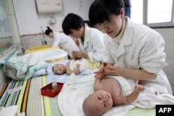 Foto yang diambil pada 15 Desember 2016 ini menunjukkan perawat tengah memijat bayi di Yongquan, China. Populasi China turun tahun lalu untuk pertama kalinya dalam beberapa dekade terakhir, menurut peneliti yang memperingatkan adanya "krisis demografis" yang berdampak pada ekonomi negara tersebut.