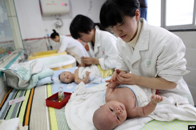Foto yang diambil pada 15 Desember 2016 ini menunjukkan perawat tengah memijat bayi di Yongquan, China. Populasi China turun tahun lalu untuk pertama kalinya dalam beberapa dekade terakhir, menurut peneliti yang memperingatkan adanya "krisis demografis" yang berdampak pada ekonomi negara tersebut.