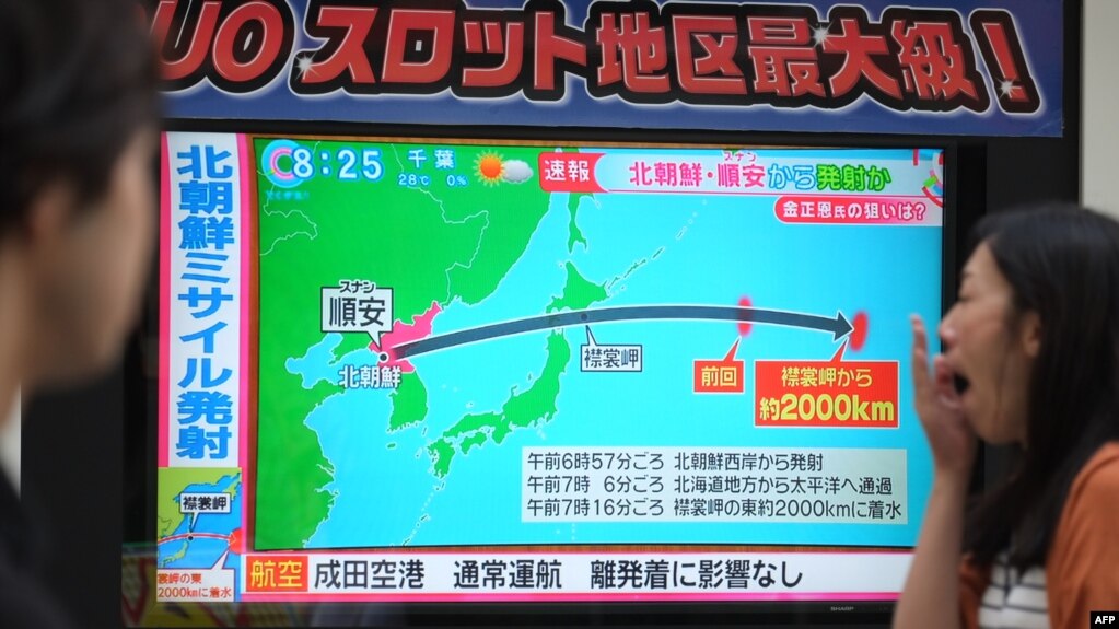 日本东京行人经过正在播放朝鲜试射导弹新闻的电子屏幕 (2017年9月15日)