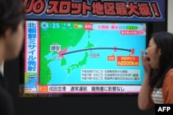 Pešaci gledaju televizijski ekran na kome se vide vesti koje javljaju o severnokorejskom probnom lansiranju rakete koja je preletela Japan, u Tokiju, 15. seprembra 2017.