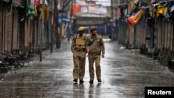 Indian policemen patrol a deserted street during a strike called by separatists to mark India's 67th Independence Day in Srinagar, August 15, 2013. 