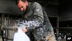 In this Jan. 16, 2017 photo, man fills a plastic container with water from a tap water in Damascus, Syria. Water cut-offs have been almost continuous since Dec. 22, in the worst water crisis known to Damascus residents