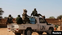 FILE - Chadian U.N. peacekeepers gesture as they patrol in Aguelhok, Mali, Jan. 24, 2014.