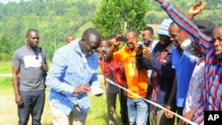 Le leader de l'opposition ougandaise Kizza Besigye nettoie ses mains après avoir voté à son bureau de vote près de sa maison de campagne dans Rukungiri environ 700 kilomètres à l'ouest de Kampala, Ouganda, 18 février 2016. 