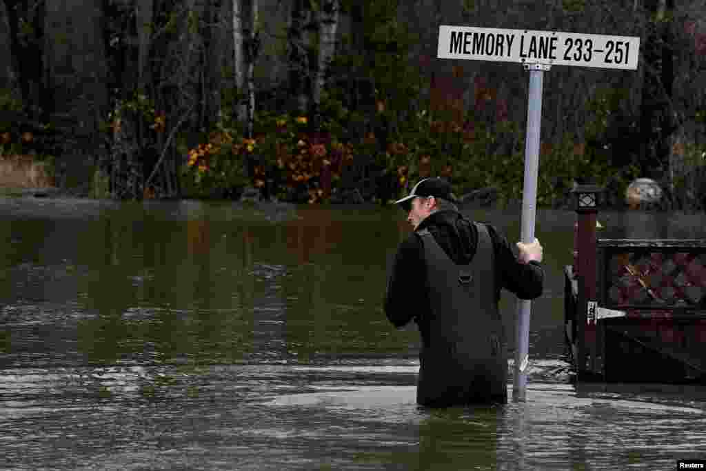 Chris Lund surveys the damage after an evacuation order was issued for the Everglades Resort on Hatzic Island after rainstorms lashed the western Canadian province, triggering landslides and floods, shutting highways, in Mission, British Columbia, Dec. 1, 2021.