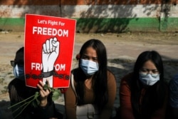 Warga Myanmar di New Delhi, India, memegang poster dalam sebuah protes menentang kudeta militer di Myanmar pada 22 Februari 2022. (Anushree Fadnavis/Reuters)