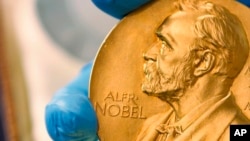 A national library employee shows the gold Nobel Prize medal awarded to the late novelist Gabriel Garcia Marquez, in Bogota, Colombia, April 17, 2015.