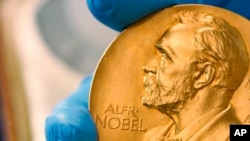 FILE - A national library employee shows the gold Nobel Prize medal awarded to the late novelist Gabriel Garcia Marquez, in Bogota, Colombia, April 17, 2015.