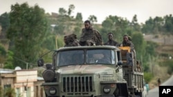 FILE - Ethiopian government soldiers ride in the back of a truck in the Tigray region of northern Ethiopia, May 11, 2021. 