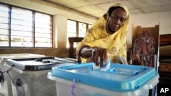 FILE - An elderly Tanzanian woman casts her vote in the presidential election at a polling station in Dar es Salaam, Tanzania, Oct. 25, 2015. 