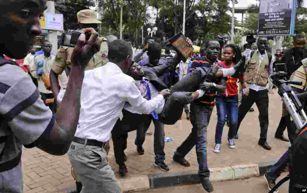 An activist opposed to the extension of presidential age limits is arrested by uniformed and plain-clothes police, near the Parliament building in Kampala, Uganda.