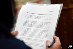 A translator reads a letter to President Donald from Chinese President Xi Jinping during a meeting Trump was holding with Chinese Vice Premier Liu He in the Oval Office of the White House in Washington, Feb. 22, 2019.