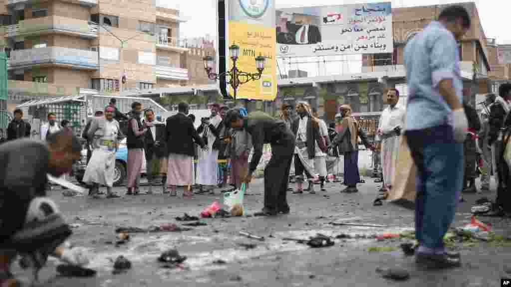 Des curieux contemplent les autorités de la sécurité prélevant les débris d&rsquo;une explosion causée par un attentat suicide &nbsp;à Sanaa, Yémen, jeudi le 9 octobre 2014. &nbsp;AP Photo 