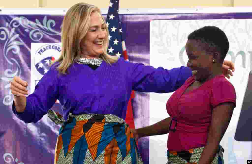 Secretary Clinton embraces Triza Lapani after the teen helped Clinton put on a chitenje cloth, a traditional skirt, after speaking at Camp GLOW (Girls Leading Our World) run by the Peace Corps, in Lilongwe, Malawi, August 5, 2012.