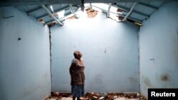 FILE - Tomasa Mozo, 69, a housewife, looks up at the roof inside the ruins of her house after an earthquake in San Jose Platanar, at the epicenter zone, Mexico, Sept. 28, 2017. 