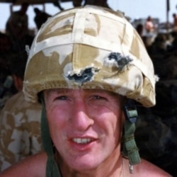 British Royal Marine Eric Walderman wears the Kevlar helmet that saved him from four bullets during fighting in southern Iraq in March 2003