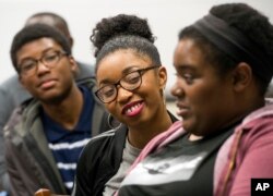 FILE - Google software engineer and Google In Residence Sabrina Williams, right, talks with freshman Alanna Walton during a class at Howard University in Washington. Acheivement gaps that begin at lower levels of schooling can continue into college.