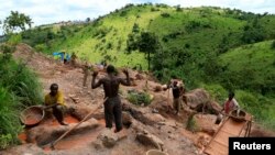 FILE - Gold miners work at an open-pit gold mine in Lukingi village in Mubende district, about 150 km (90 miles) southwest of Uganda's capital Kampala.