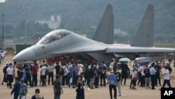 Visitors look at the Chinese military's J-16D electronic warfare airplane during 13th China International Aviation and Aerospace Exhibition, also known as Airshow China 2021, on Wednesday, Sept. 29, 2021, in Zhuhai in southern China's Guangdong province. 