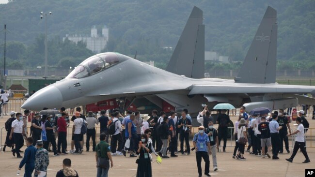Visitors look at the Chinese military's J-16D electronic warfare airplane during 13th China International Aviation and Aerospace Exhibition, also known as Airshow China 2021, on Wednesday, Sept. 29, 2021, in Zhuhai in southern China's Guangdong province.