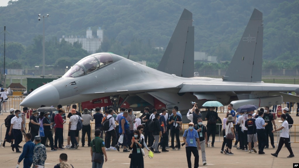 FILE - Visitors look at the Chinese military's J-16D electronic warfare airplane during an air show, Sept.&nbsp;29,&nbsp;2021, in Zhuhai, China. Some observers are warning that&nbsp;the U.S. faces an uncertain future in which China and other nations could challenge its technological dominance.
