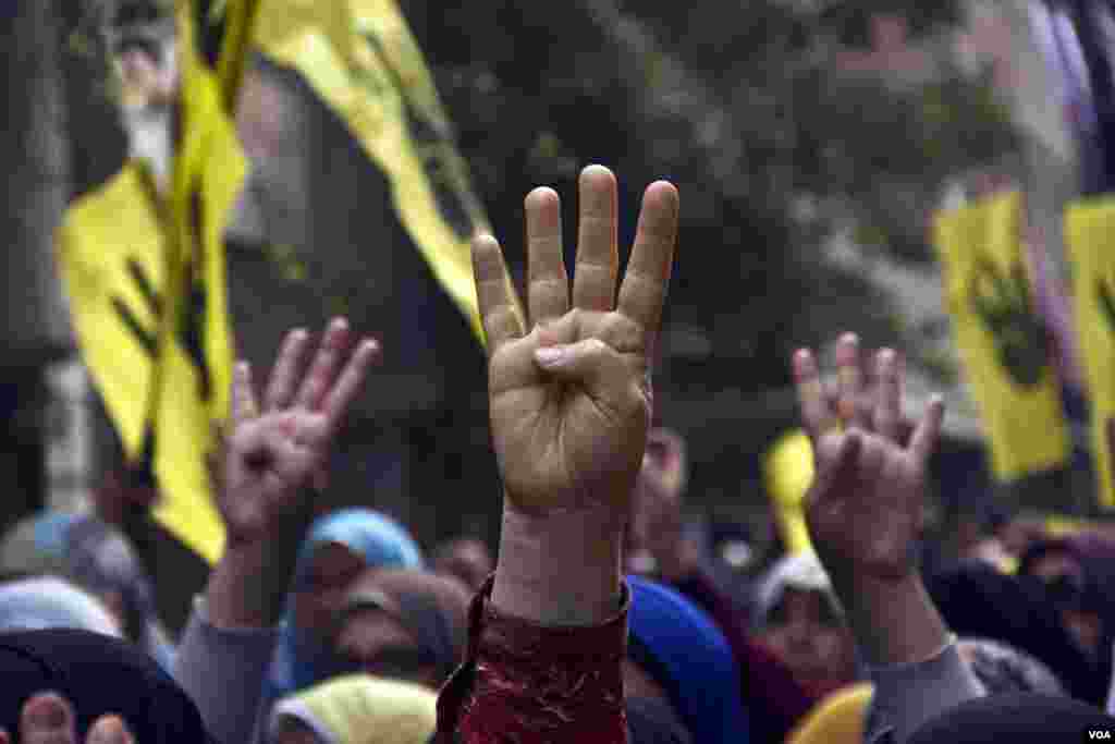 Protesters raise their hands with the four finger sign representing Rabaa during a march in Maadi, Cairo, on the six month anniversary of the violent crackdown against supporters of ousted President Mohamed Morsi, Feb. 14, 2014. (Hamada Elrasam/VOA) 