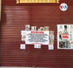 Un cartel explica el porqué del cierre del negocio [Foto: Fabiola Chambi, VOA]