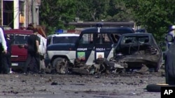 This image taken from AP video shows the scene of a blast with wreckage of a police car and debris littered over the ground in Makhachkala in the southern Russian region of Dagestan, May 25, 2013.