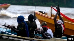 Des combattants du Mouvement pour l'émancipation du Delta du Niger (MEDN) patrouillent dans les ruisseaux de la rivière Bonny, près de l'usine de GNL, dans la région pétrolière du delta du Niger, dans le sud du Nigeria, 18 septembre 2008. EPA / GEORGE Esi