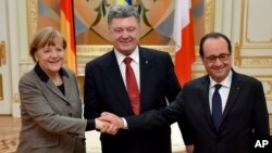 Ukrainian President Petro Poroshenko, center, German Chancellor Angela Merkel, left, and French President Francois Hollande show solidarity during their meeting in Kyiv, Ukraine, Feb. 5, 2015.