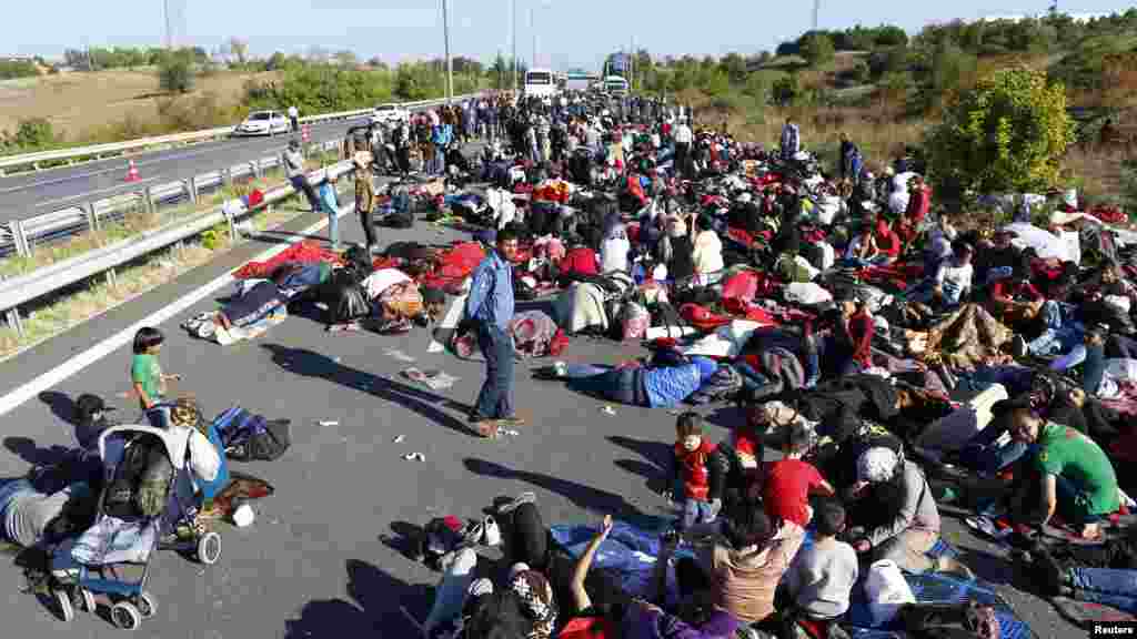 Plusieurs hommes, femmes et enfants manifestent sur une autoroute bloquée par des policiers et des gendarmes&nbsp;turques qui font barrage à des centaines de migrants principalement syriens près d&rsquo;Edirne, en Turquie, 19 septembre 2015.&nbsp;