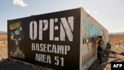 Artist Brandy Whisenant paints a mural prior to Storm Area 51 Basecamp at the Alien Research Center near Hiko, Nevada.(Photo by Bridget BENNETT / AFP)