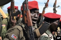 FILE - Government soldiers follow orders to raise their guns during a military parade in Juba, South Sudan, April 14, 2016.