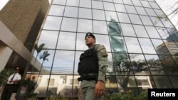 Seorang polisi berdiri di depan kantor Mossack Fonseca di Panama City (12/4).
