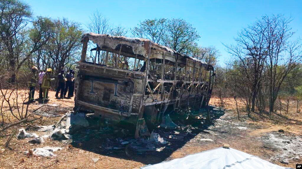 Emergency services stand near to a burned out bus after a bus accident in Gwanda about 550 kilometres south of the capital Harare, Nov. 16, 2018. Police in Zimbabwe say more than 40 people have been killed in a bus accident Thursday night.
