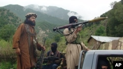 FILE - Militants of the Pakistani Taliban patrol in their then-stronghold of Shawal in the Pakistani tribal region of South Waziristan, Aug. 5, 2012.