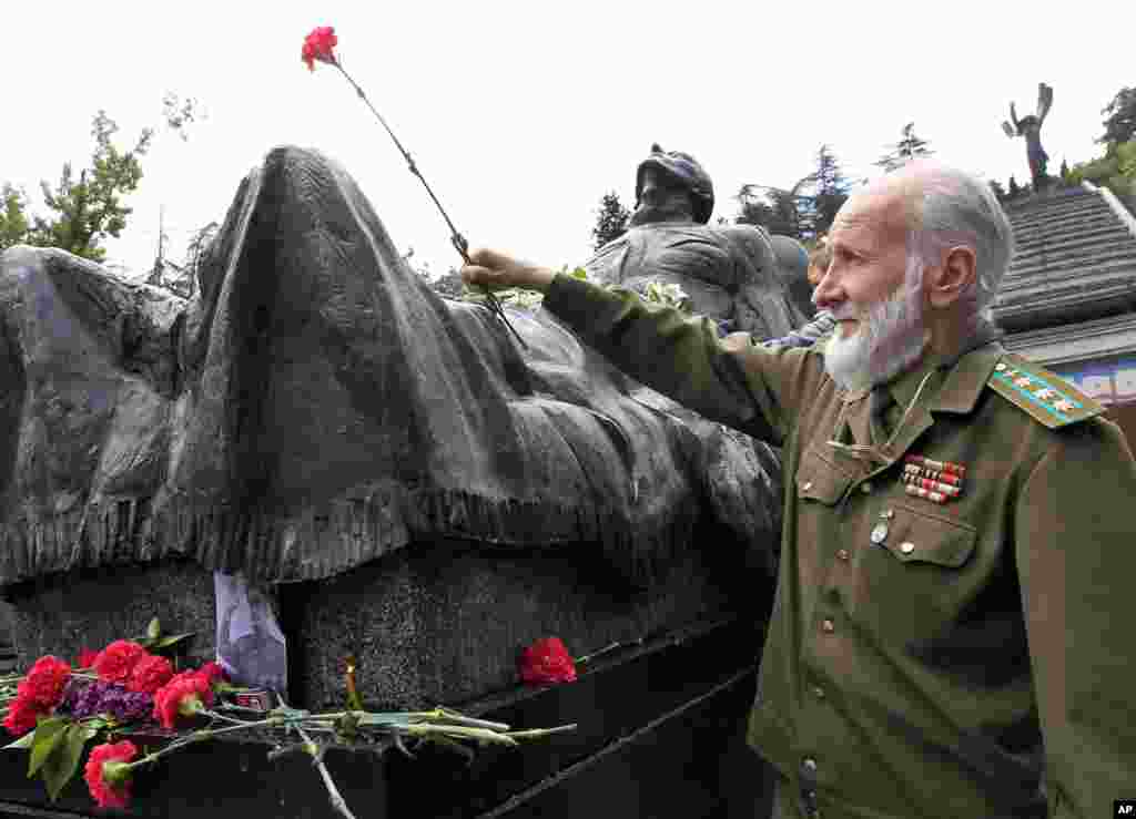 Тбилиси, Грузия: ветеран возлагает цветы к мемориалу войны &nbsp;