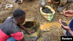 FILE - An artisanal miner washes tin ore before it is bagged up and weighed, ready to be transported to the nearest major town for export in the Kalimbi tin mine near the small town of Nyabibwe, D.R.C.